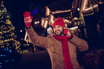 Photo of cheerful excited person speak telephone arm glove waving hi walking town center outdoors