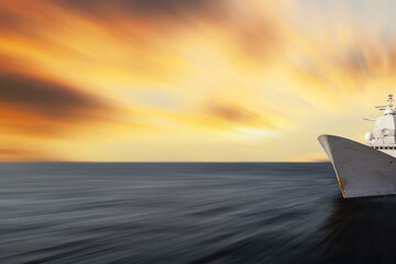 Blurred seascape with a warship at the edge of the image. Abstract motion blurred sea with sunset...