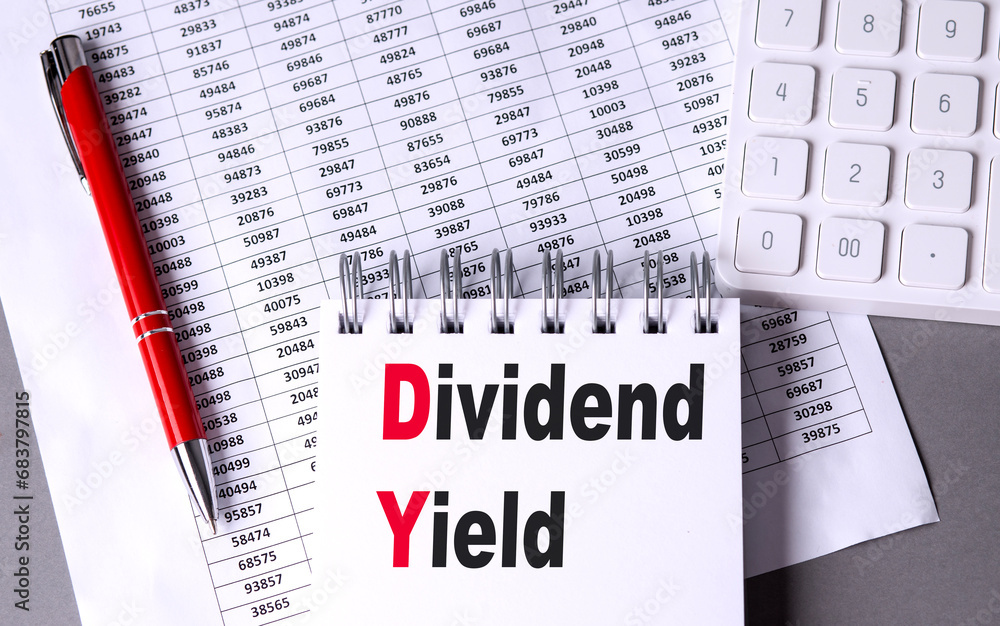 Poster dividend yield text on notebook with pen, calculator and chart on grey background