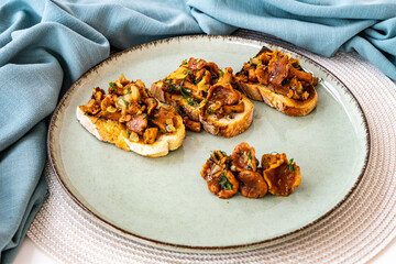 Bruschetta with pan fried chanterelle mushrooms with olive oil, onion, garlic, and dill on a green ceramic plate. Home cooking, eating healthy.  Italian dish. Closeup of vegetarian dish - Powered by Adobe