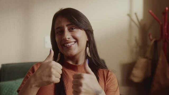 Mulher de etinia indigena jovem de de cabelos pretos e longos fazendo sinal de positivo. Cinematico 4k.