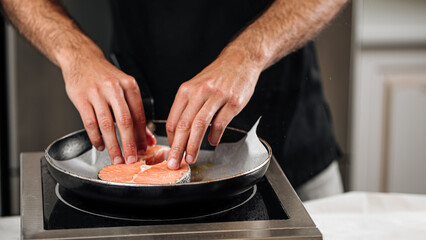 Man cooking salmon steak roasting on parchment paper