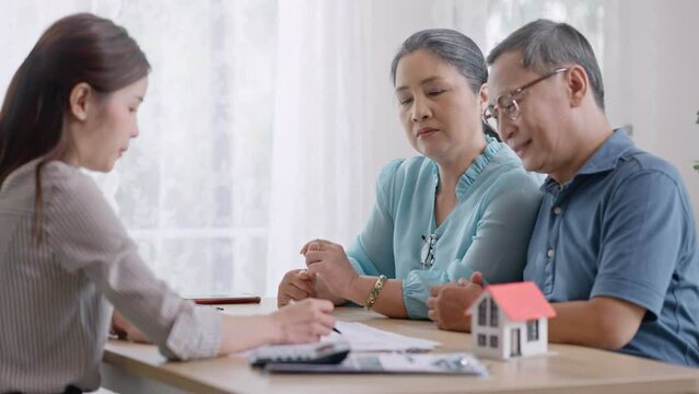 Ownership and New home,retirement concept.real estate agent give keys to new home to excited asia elderly couple clients.Asian Woman realtor or broker congratulate happy overjoyed with house purchase.