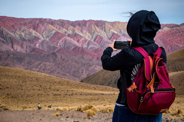 Mujer turista tomando una foto en su excursión por el Hornocal, en Jujuy, Argentina