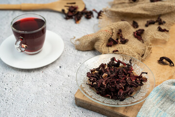 Hibiscus tea glass cup and dried flowers on white background. Vitamin, recipe, beverage concept. 