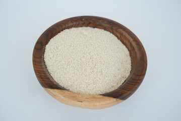 dry garlic powder on a wooden plate isolated on a white background