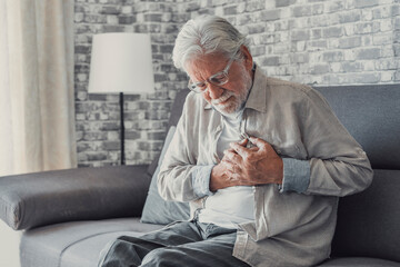 Worried elder senior man feeling bad, upset old middle aged grandfather touching chest feel sudden...