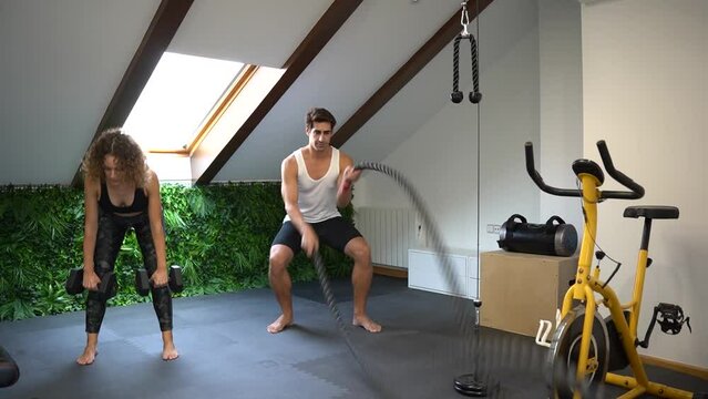 Adult couple working out in home gym with equipment in daylight