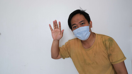 Man in a face mask gesturing stop, promoting health safety