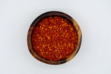 Dry chili peppers on a wooden plate isolated on a white background
