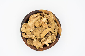 Dried Organic Ginger root on a wooden plate isolated on a white background
