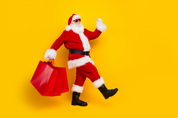 Full length photo of santa walk holding red packages black friday winter holiday merry christmas...