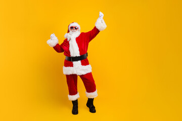 Fototapeta na wymiar Full body photo of satisfied aged santa raise fists triumph empty space christmas noel ad isolated on yellow color background