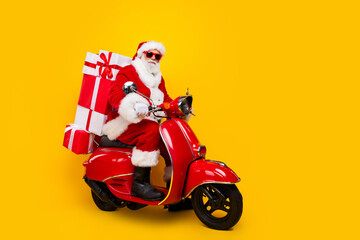 Full length photo of riding moped saint nicholas courier express new year delivery from north pole isolated on yellow color background