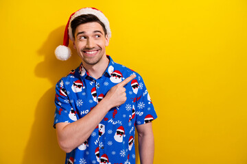 Photo of young guy brunet hair wear santa claus hat indicating finger mockup happy new year event...
