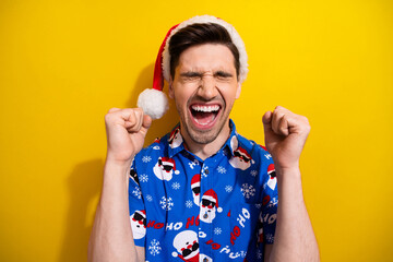 Photo of crazy man raised fists up open mouth yelling wishes dreams comes true hooray holly jolly xmas isolated on yellow color background