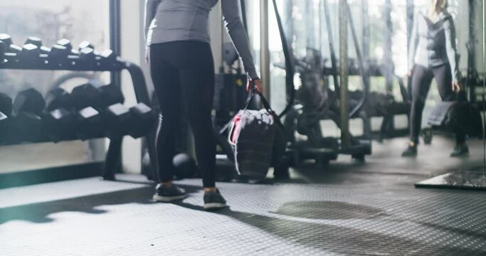 Athlete, walking and woman with a bag in gym ready to start exercise, workout or training on floor with weights. Fitness, club and legs of person with health, wellness and equipment in gymnasium