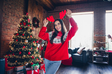 Photo of overjoyed positive cool girl preparing new year party decorating room dancing dressed...