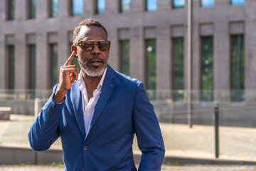 Mature african businessman using earphones to talking to the mobile