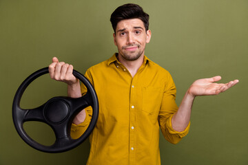 Photo of clueless person arm hold steering wheel shrug shoulder not know isolated on khaki color...