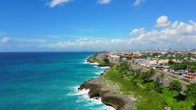 Aerial view of The Autopista Las Americas along the rocky shore. Turquoise caribbean sea and huge waves crashing on the stones. Expressway from the Punta Cana to the Santo Domingo 