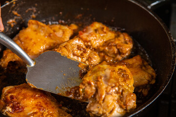 Turn the chicken in spices in a frying pan with an iron spatula.