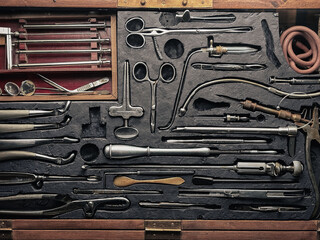 A set of old surgical instruments in a wooden case