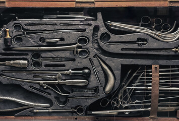 A set of old surgical instruments in a wooden case