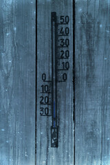Thermometer an einer Holzwand bei Minus-Temperaturen
