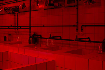 Red room for developing photographs. White tiles with flasks and special chemicals under red light