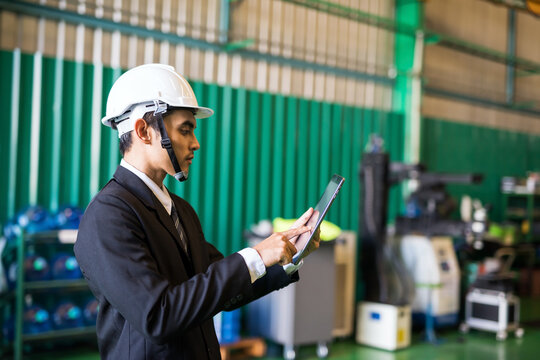 Factory manager check inventory stock on tablet in warehouse