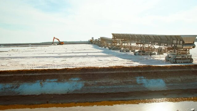 Natural salt production fields or salt flats in Marismas del Odiel, Huelva, Andalucia, Spain, where evaporation pools turn seawater into white gold, and salt is harvested using machinery