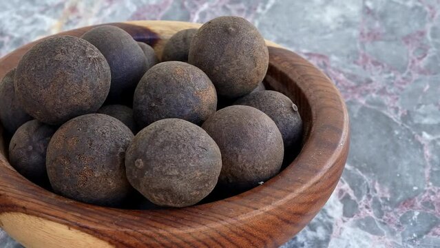 Dry Black Lemon on a brown wooden plate on blue marble,pan, close, HD, 24fps
