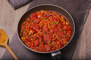 Chorizo stew resting in a pan shot from above.
