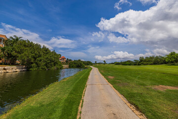 Scenic tropical landscape on Aruba Island, blending lakes, hotel with golf course, and lush greenery into picturesque oasis.
