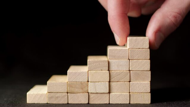 Rising chart, graphs. Successful career growth in business.  Hand laying wooden blocks in the form of a staircase. 
