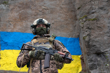 Ukrainian soldier against ukrainian flag is painted on a granite rock