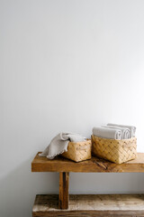 Vertical shot of woven baskets with clean towels on wooden bench in bathroom