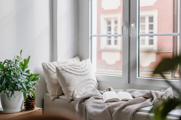 Cozy corner for reading books on windowsill in nordic style room