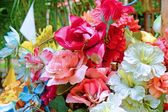 Colorful artificial bouquet of flowers with background of green garden