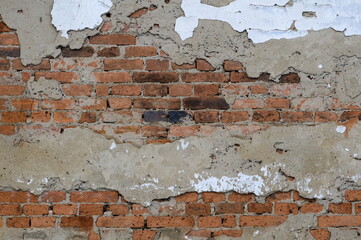 Damaged brick wall facade of very old house. Abstract background photo. Ideal for placement of text.