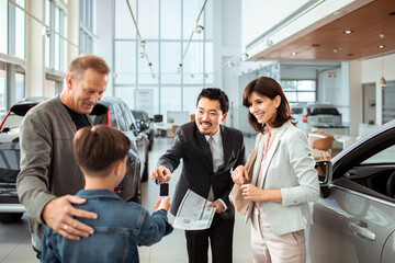 Family at Car Dealership Buying New Vehicle with Salesperson