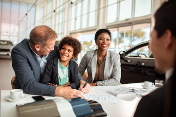 Family at Car Dealership Buying New Vehicle with Salesperson