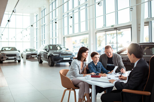 Family at Car Dealership Buying New Vehicle with Salesperson