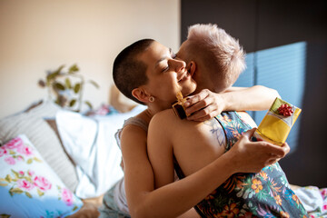 Young female couple celebrating a birthday in the bedroom