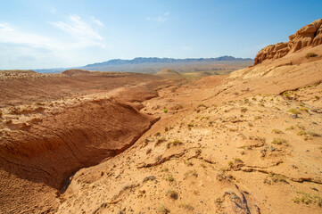 Witness nature's fiery masterpiece as the sun bids farewell behind the Red Boguty Mountains. Desert Dreams