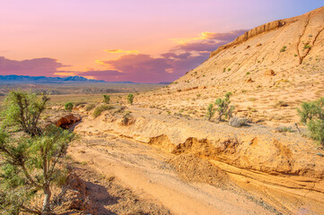 Enjoy the mesmerizing beauty of a desert sunset in the Red Bogut Mountains Witness the golden glow of the sun illuminating the jagged peaks Be captivated by the breathtaking awe inspiring spectacle