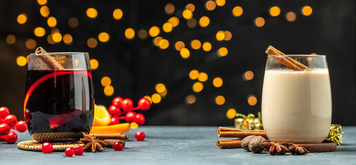 glasses of mulled wine and eggnog, Christmas winter alcohol drinks decorated by christmas lights....