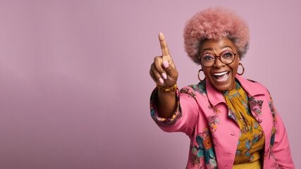 Happy senior afro woman points her finger at copy space for promotion - obrazy, fototapety, plakaty