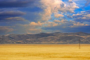 Steppe, prairie The sky sparkles with fiery hues as the sun dips below the horizon, leaving the...